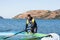 Sportsman preparing his windsurfing equipment in shallow water