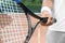 Sportsman with racket at tennis court, closeup