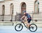 Sportsman riding bike next to old building