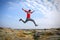 Sportsman running, jumping over rocks