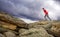 Sportsman running, jumping over rocks in mountain area.