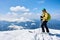 Sportsman skier on skis on background of blue sky and highland landscape. Winter skiing concept.