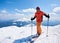 Sportsman skier on skis on background of blue sky and highland landscape. Winter skiing concept.