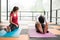 Sportsman and sportswoman practicing yoga and stretching on mat at gym.