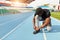 Sportsman ties his trainers, sitting on the running track, preparing