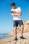 Sportsman using smartphone standing on the beach