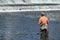 Sportsman in Waders Fishing at Dam