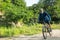 A sportsman who rides a mountain bike on a forest trail, wearing a face mask against air pollution and covid19 coronavirus.