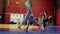 Sportsmen do cartwheels on tatami in spacious modern gym