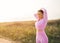 Sportswoman with beautiful aesthetic body ties her hair in a ponytail before jogging along a deserted steppe road