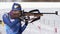 Sportswoman biathlete aiming, rifle shooting in standing position. Biathlete Miroshnichenko Maria Kamchatka in shooting