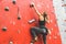 Sportswoman climber moving up on steep rock, climbing on artificial wall indoors. Extreme sports and bouldering concept