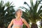 Sportswoman doing fitness exercise outside in palm park