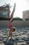 Sportswoman doing handstand on beach