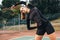 Sportswoman doing stretching workout on tennis court