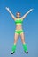 Sportswoman in green sportswear and sunglasses jumping with hand