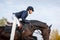 Sportswoman jumps a horse over an obstacle