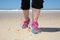 Sportswoman runner getting ready running shoes on beach.