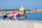 Sportswoman in sportswear and sunglasses doing push ups on seafront