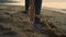 Sportswoman stretching reaching hand to leg outdoor. Girl doing warm-up on sand.