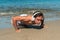 Sporty adult man in headphones doing push-ups on seashore
