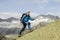 A sporty alpinist climbs a mountain summit in the Swiss Alps