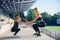 Sporty beautiful elder and younger sisters which squating together during fitness training outdoors.