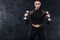 Sporty beautiful woman with dumbbells makes fitness exercising at black background to stay fit