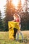 Sporty, blonde woman with curly hair putting tent, making campsite.