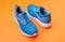 sporty blue sneakers pair on orange background, fitness