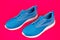 sporty blue sneakers pair on pink background, sport fashion