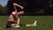 Sporty brunette stretching on grass