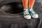 Sporty child in sportswear standing on tire at fitness studio