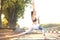 Sporty concentrated woman practicing yoga, standing in anjaneyasana pose, working out in park on sunset