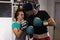 Sporty couple in boxing gloves standing near boxing punching bag