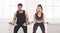 Sporty couple making exercise with dumbbells on endurance