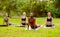 Sporty diverse girls on morning yoga practice, doing cobra pose at park