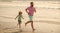 sporty family of daddy man and child boy running on beach together, summer