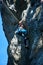 Sporty female climber ascending high rocky mountain.