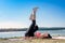 Sporty fit woman practices yoga  near lake at daytime. Healthy life exercise concept