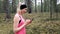 Sporty fitness woman using smart phone after workout in forest