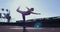 Sporty girl is doing yoga on a sunset. Pose of a swallow on the roof of the building. High quality 4k footage. 18 of