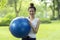 Sporty girl holding gymnastic ball for exercise outdoor at park