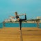 Sporty girl is practicing yoga on the seashore