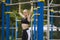 Sporty girl pulled on the bar in a sports suit