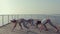 Sporty girls shaking their butts on the pier near sea