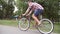 Sporty guy cycling at the park road. Young handsome man riding a vintage bicycle outdoor. Healthy active lifestyle. Side