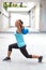 Sporty hispanic woman in blue demostrating a routine with blue kettlebell outdoors