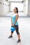 Sporty hispanic woman in blue lifting blue kettlebell for dead lift, outdoors
