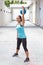 Sporty hispanic woman in blue lifting blue kettlebell for routine outdoors